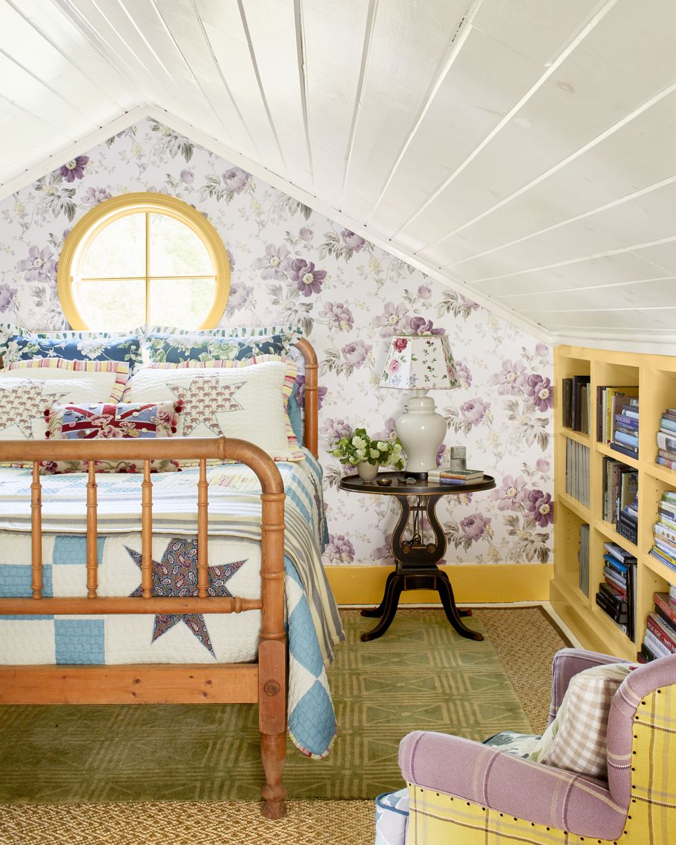 attic bedroom with purple floral wallpaper and wood bed with quilt