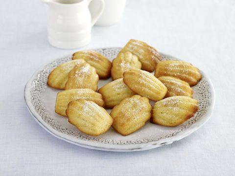 Madeleines served on plate, small white jug in background