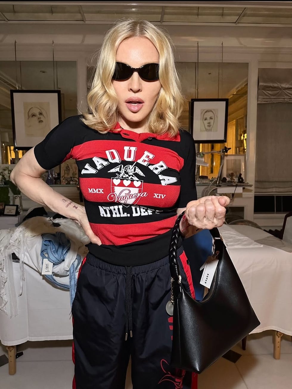 Persona vestida con un traje rojo y negro sosteniendo un bolso negro