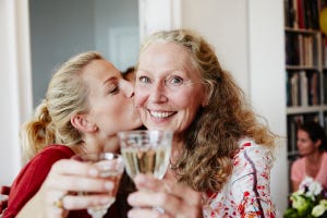 madre e hija brindando con vino blanco