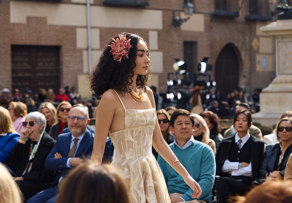 fashion model walking during a runway event in an outdoor setting