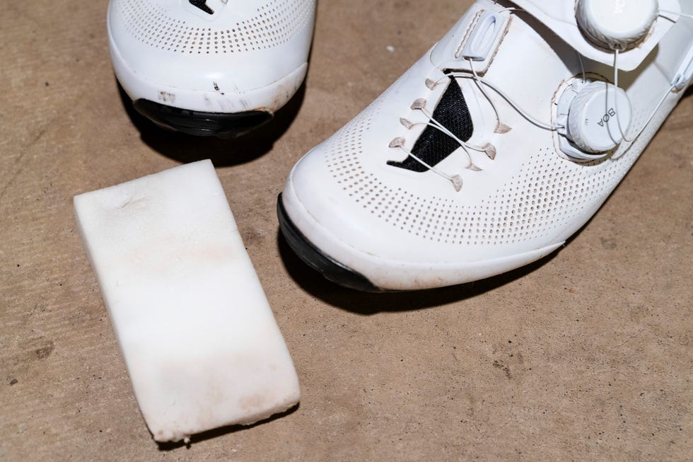 cycling shoes and a magic eraser on a concrete surface