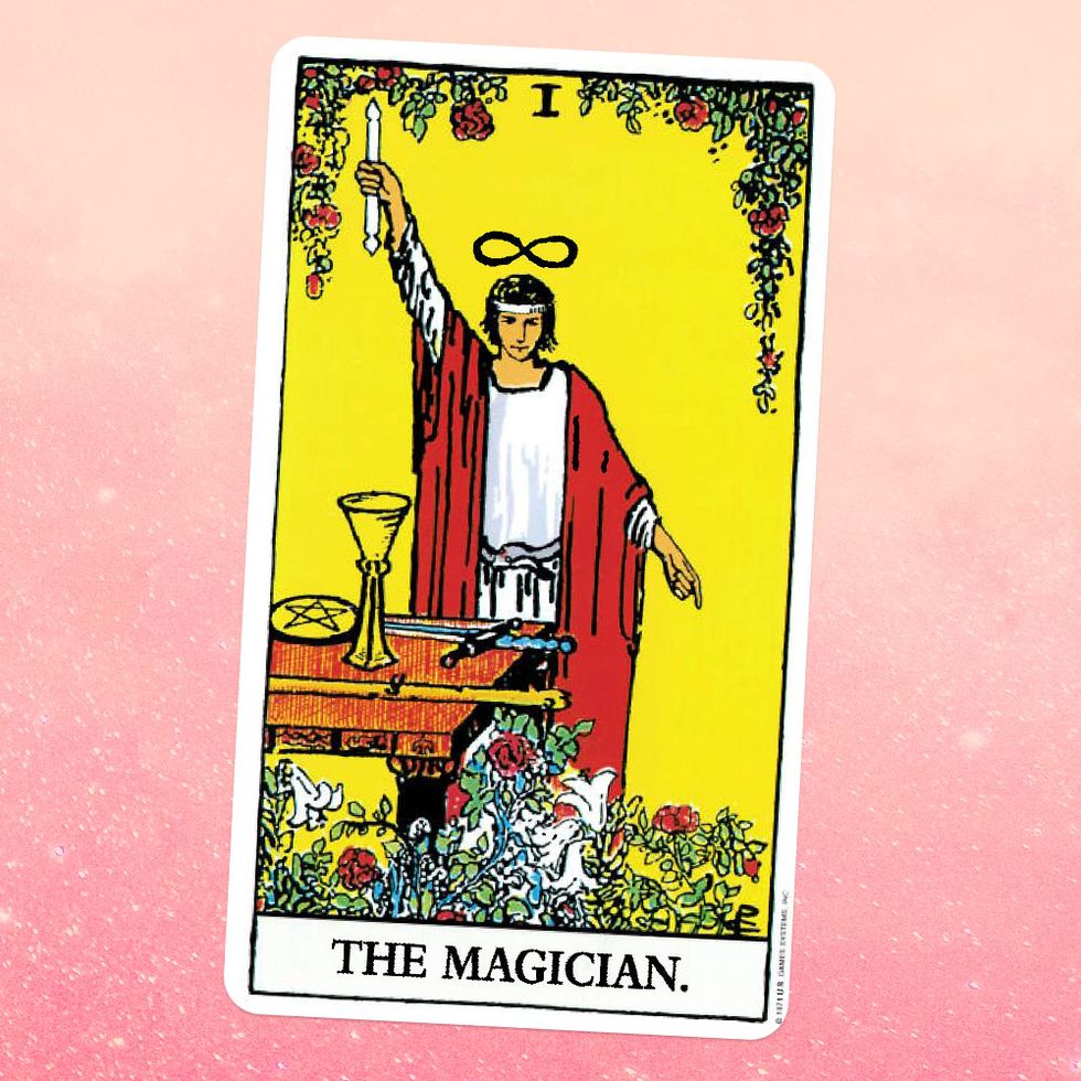 the tarot card the magician, showing an androgynous white figure in a white tunic and red robe with an infinity symbol over their head like a halo, holding up a wand on a tale in front of them lies a goblet, a coin, a sword, and a wooden staff they're surrounded by flowers