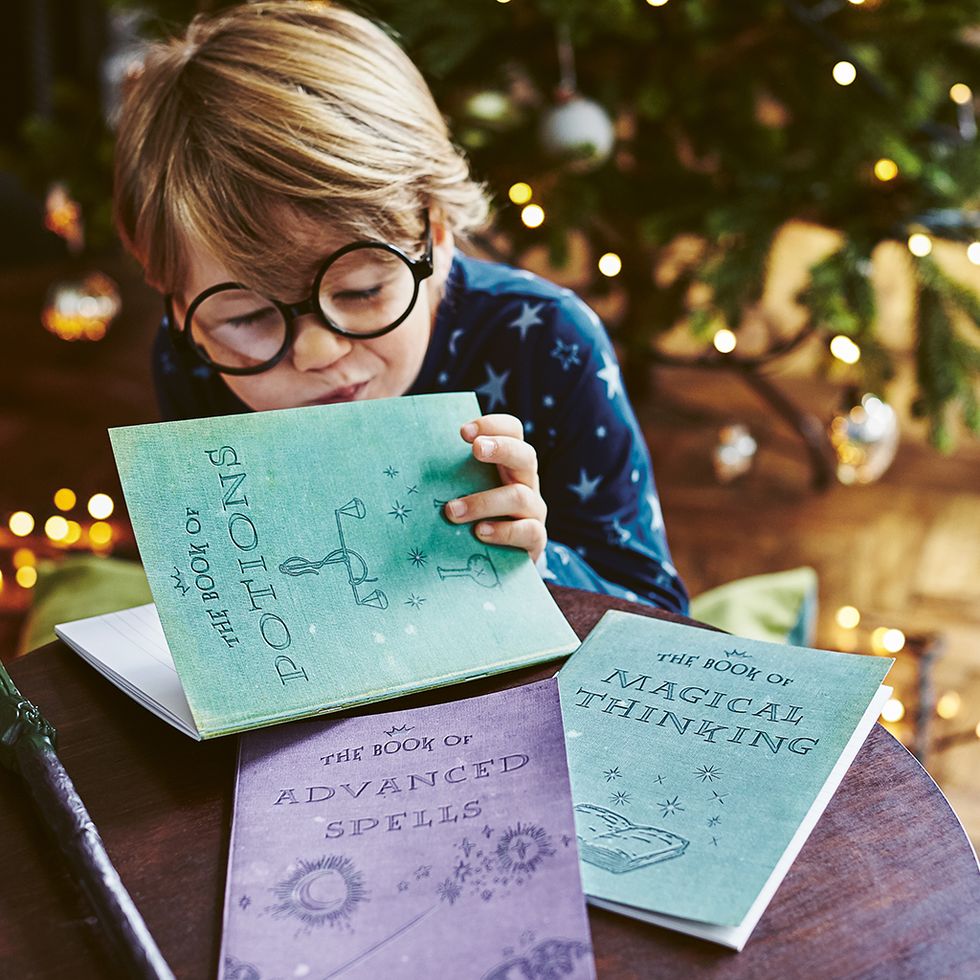 Little boy in glasses looking in the notebooks