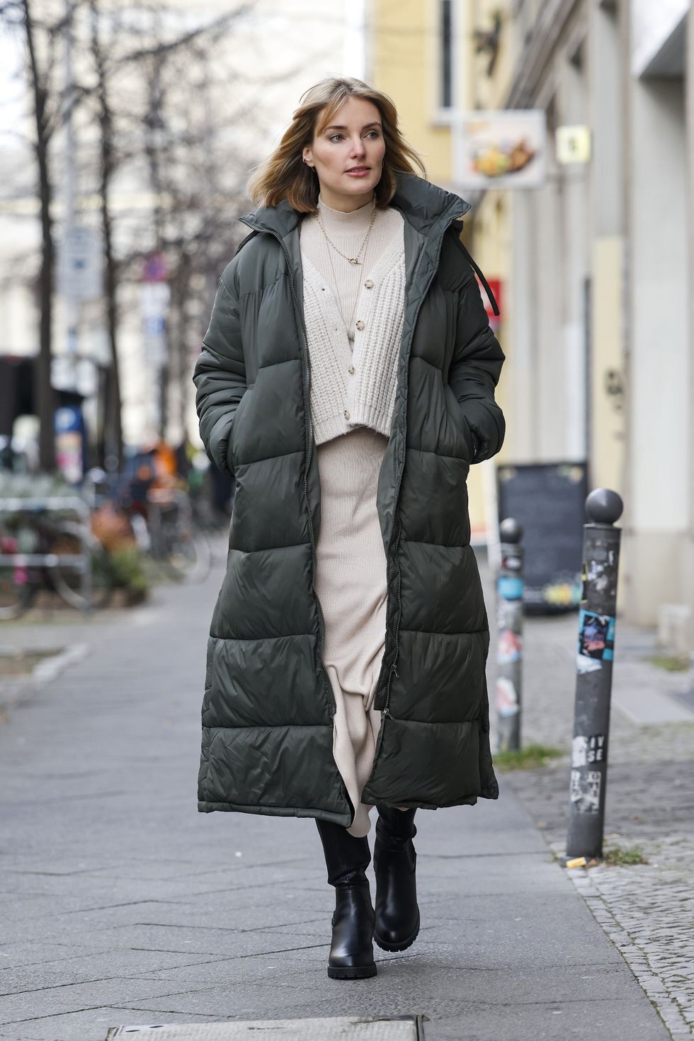 berlin, germany   december 15 influencer marie von den benken alias regendelfin wearing a blonde fringe bob hairstyle, a long army green down puffer coat   leger by lena gercke, a beige knitted top and matching skirt with a slit   leger by lena gercke, a short beige cardigan by oak  fort and black knee high boots by anna field via zalando during a street style shooting on december 15, 2020 in berlin, germany photo by streetstyleshootersgetty images