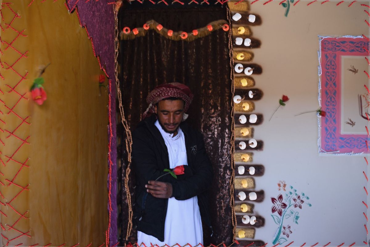 Een met borduurwerk versierde foto van Mahmoed Abdo siert de muur van zijn huis in het dorp Al Tarfa Zijn nicht Nora Mohammed bracht de borduursels aan