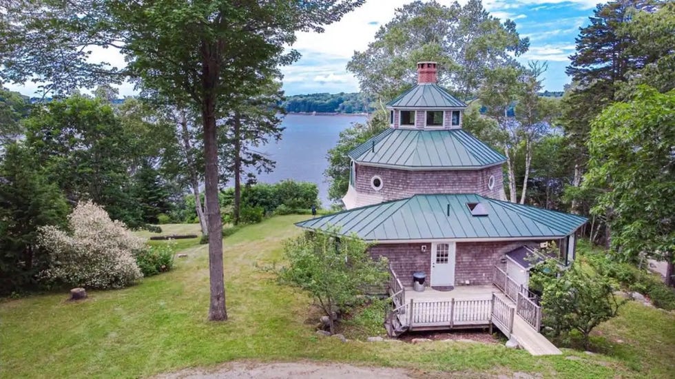 a house with a green roof by a lake