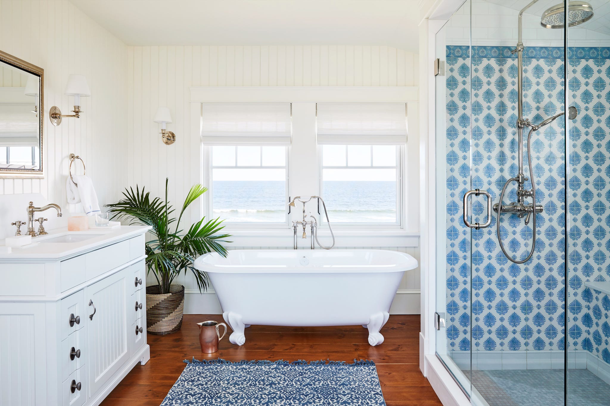 white bathroom with blue and white tile in shower