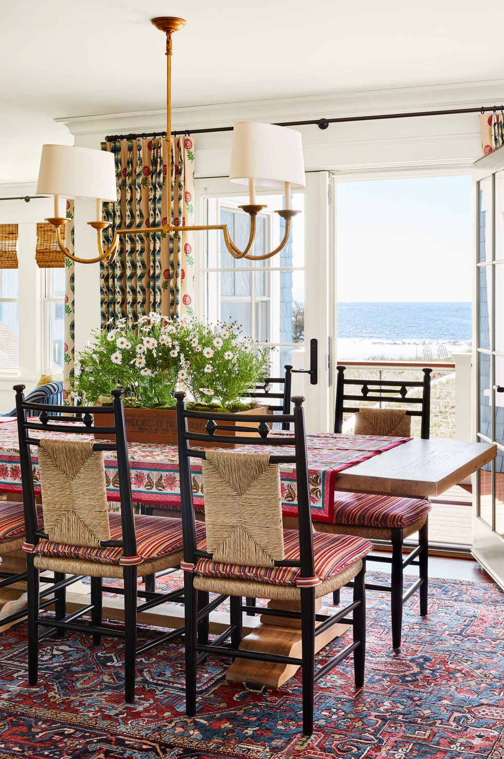 pattern filled dining room with french doors that open out to a beach view