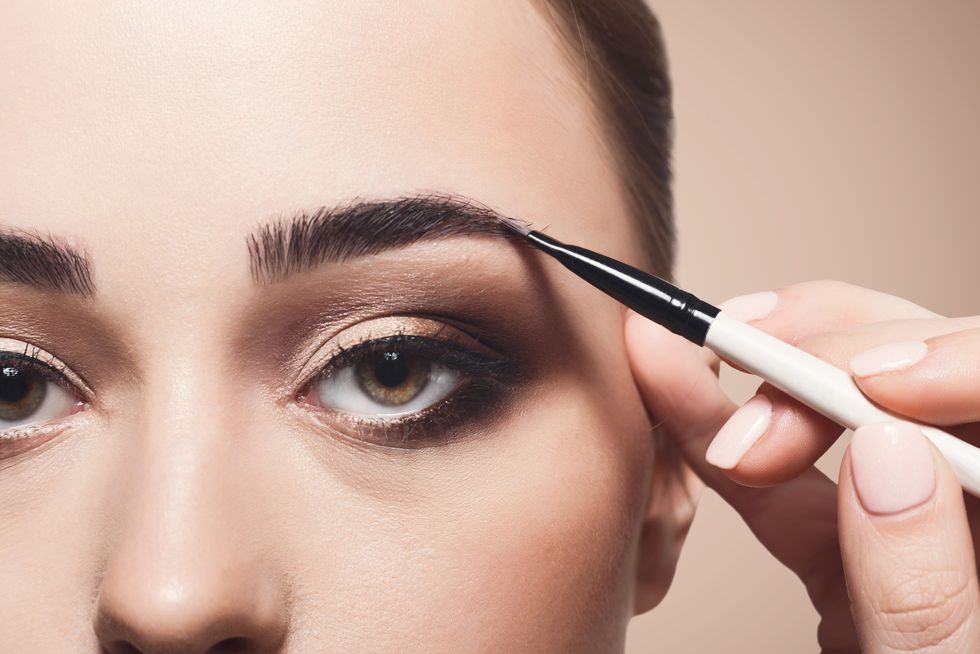 Make-up artist apply eyebrow shadow with brush, beauty