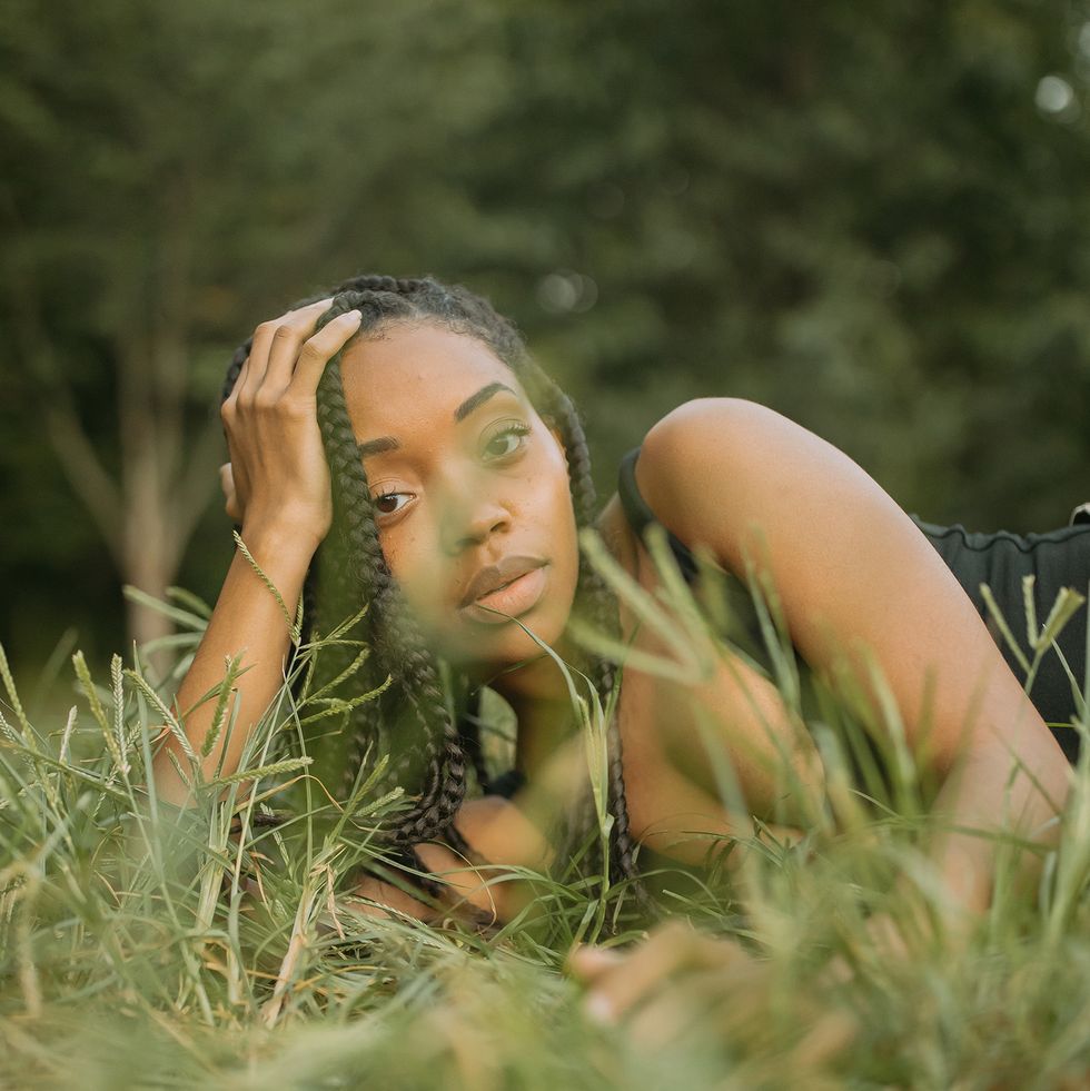 makeda sanford is lying down on a bed of grass