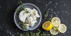 Making feta cheese, olive oil and thyme dip or sauce. On dark background, top view