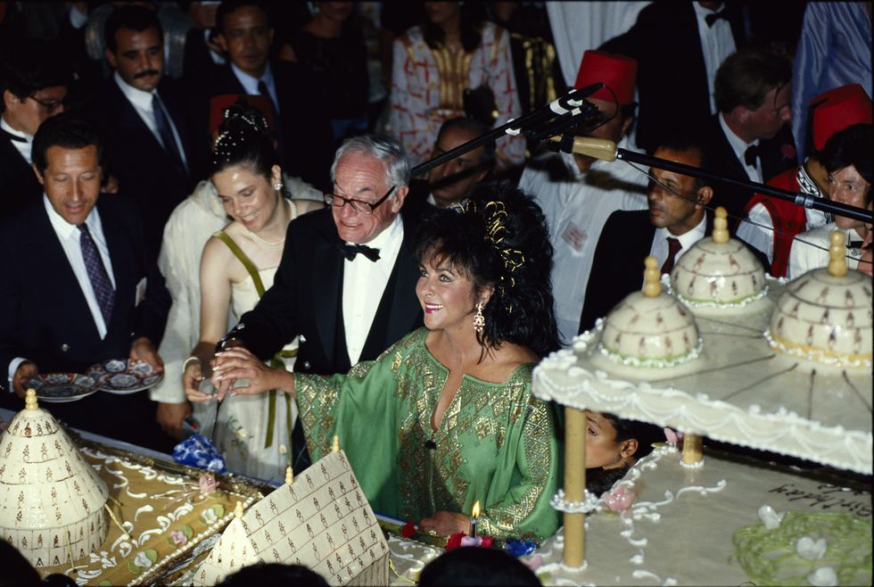 malcolm forbes and liz taylor in front of dessert buffet 1989