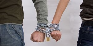 male and female hand locked in chains