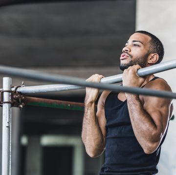 male athlete doing chin ups in a gym