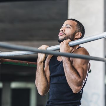male athlete doing chin ups in a gym