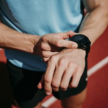 male athlete on tartan track checking smartwatch