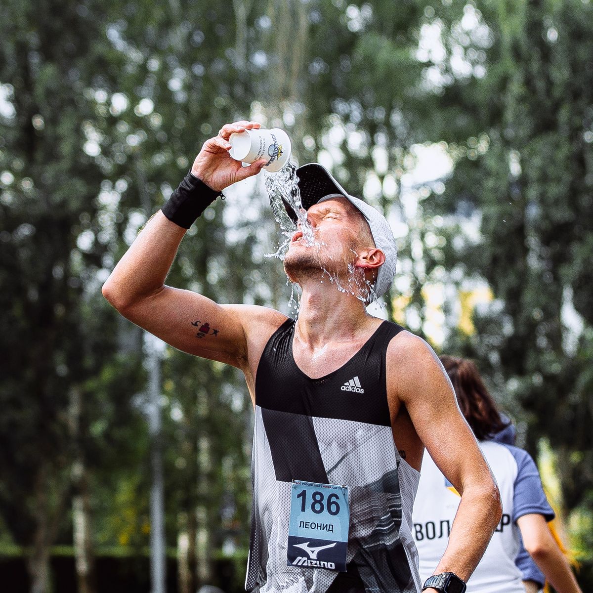 male athlete runner hot weather pouring water on head