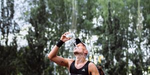 male athlete runner hot weather pouring water on head