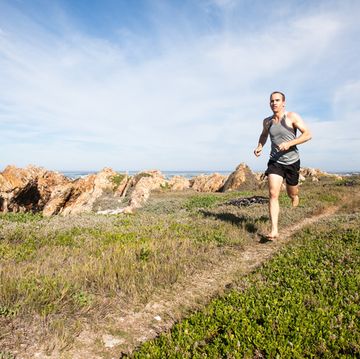 male athlete running barefoot and fast on a walking trail