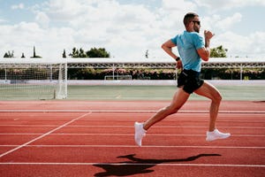 male athlete running on tartan track