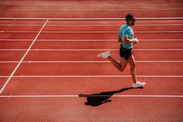 male athlete running on tartan track