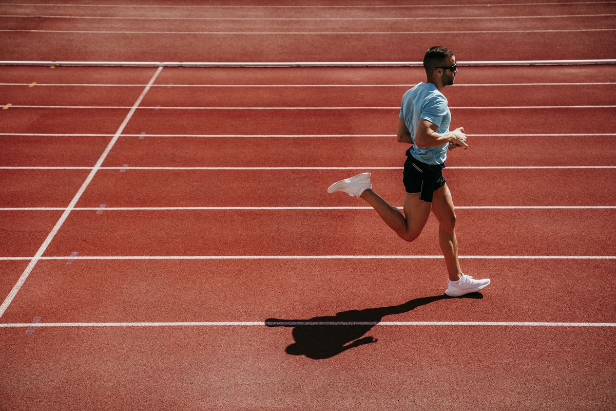 male athlete running on tartan track