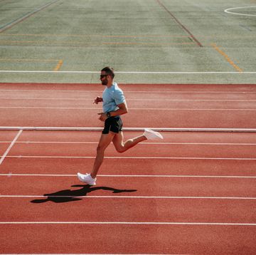 male athlete running on tartan track