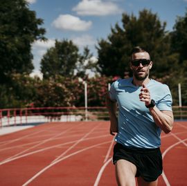 male athlete running on tartan track