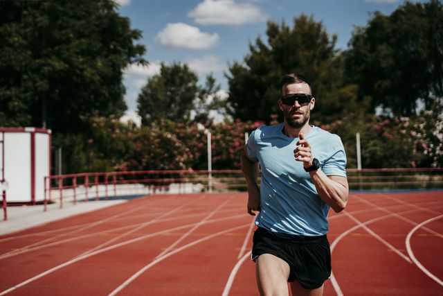 male athlete running on tartan track