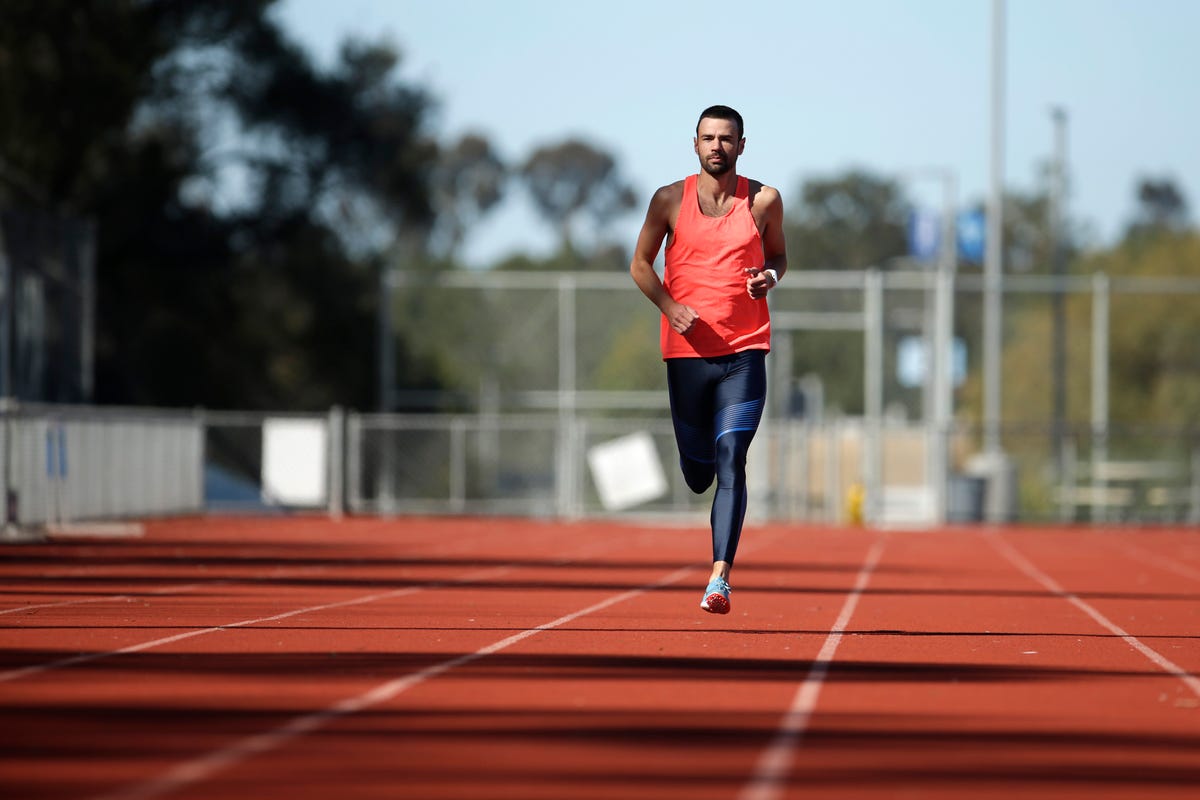 a male athlete runs on a track