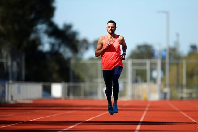 a male athlete runs on a track