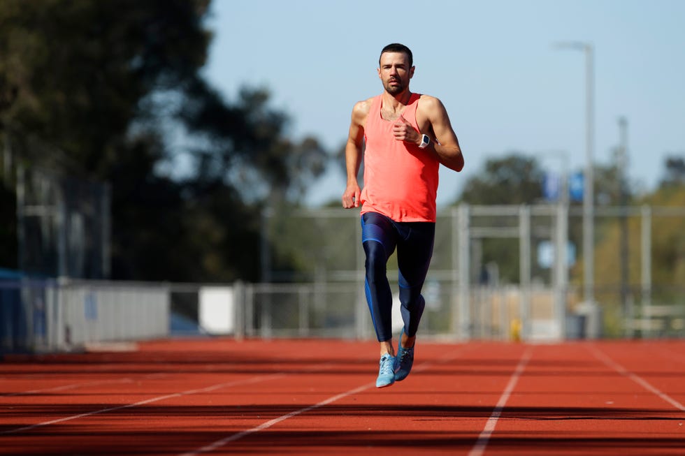 a male athlete runs on a track