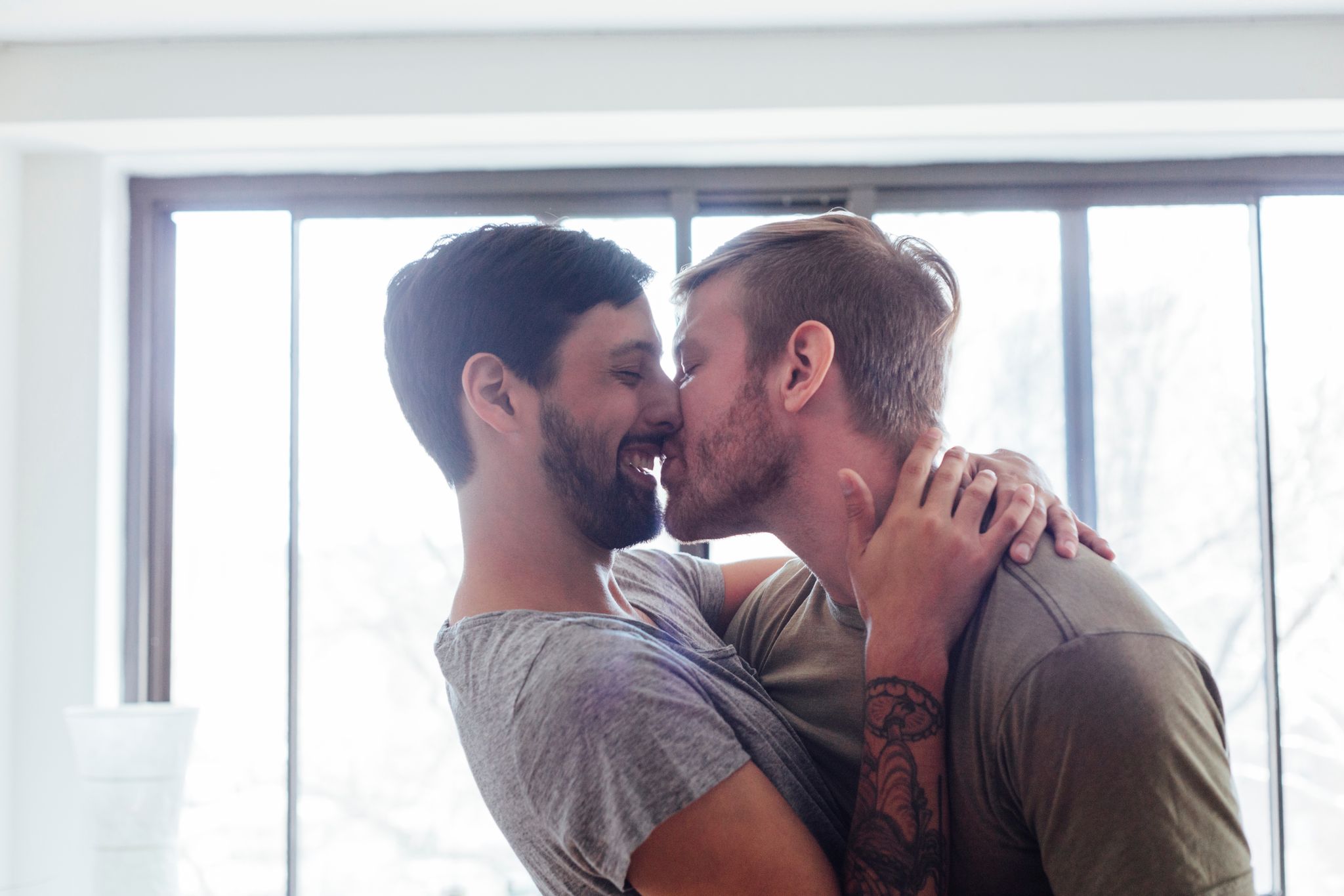 Male couple at home,fooling around, kissing and laughing