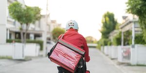 male delivery guy on bicycle with backpack in the city