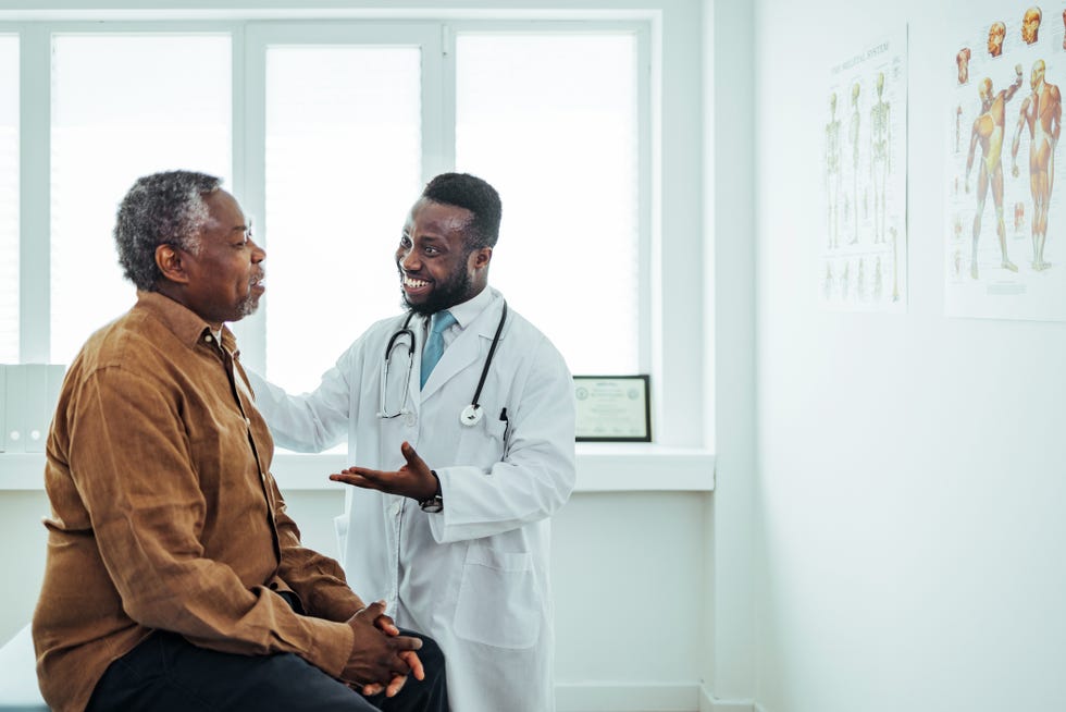 a male doctor chats to an elderly male patient