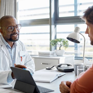 Male doctor discussing with patient in clinic male doctor discussing with patient in clinic