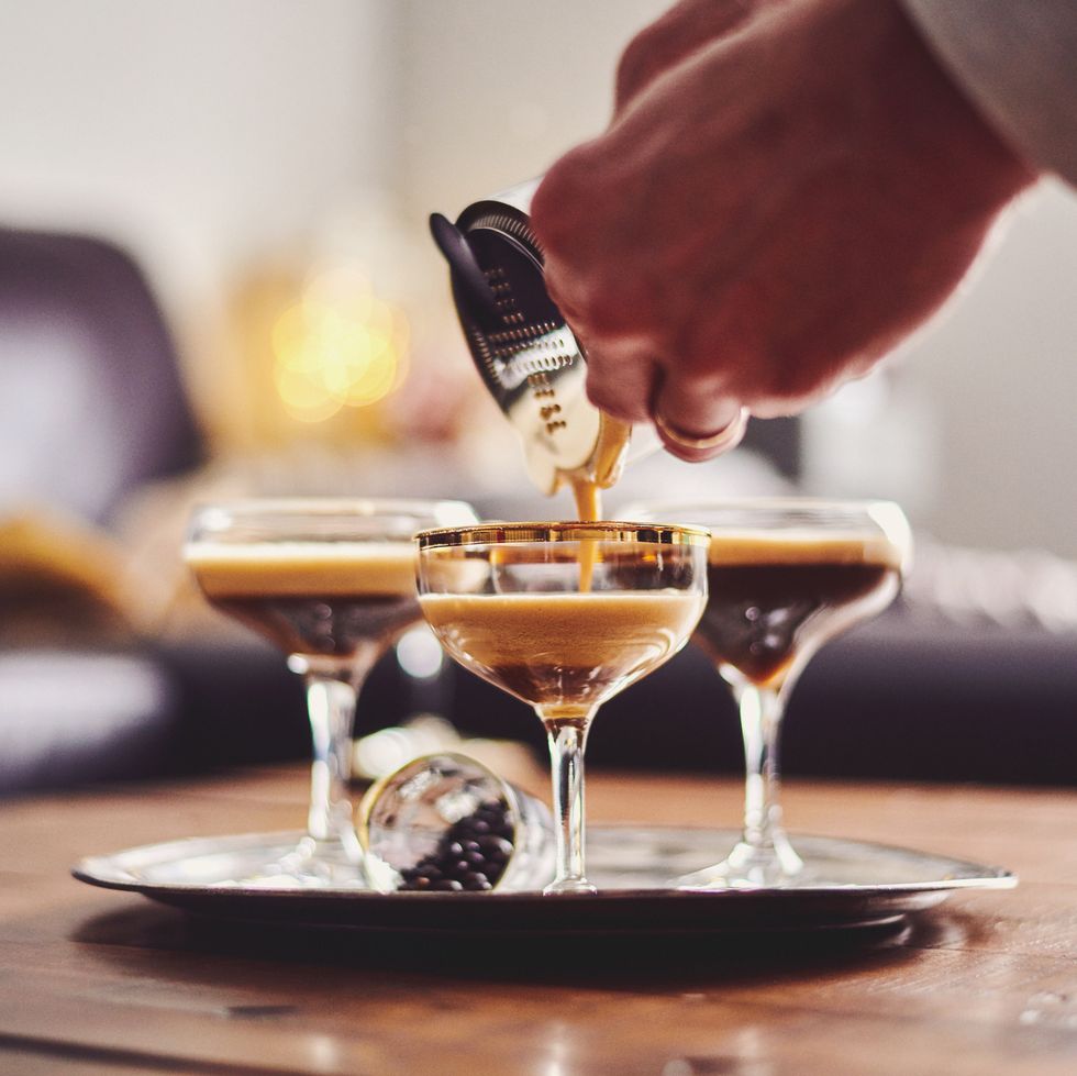 male hands pouring espresso martini cocktail into glass