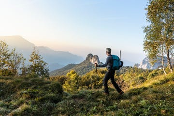 male hiker walking on mountain against sky during sunrise, orobie, lecco, italy