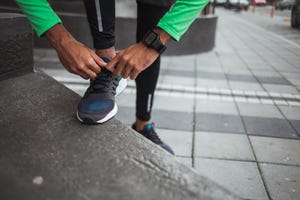 Male jogger tying his shoe