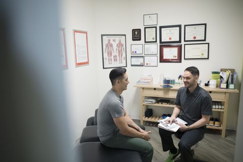 Male physiotherapist talking with client in office
