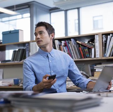 male professional in office holding technology