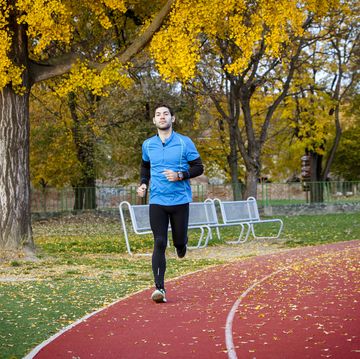 male runner jogging on running track