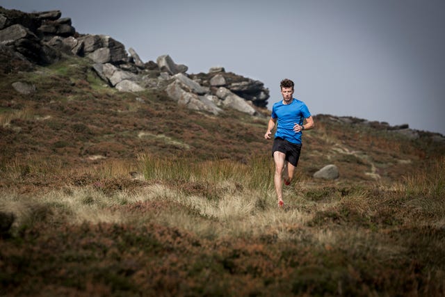 male runner running down from stanage edge, peak district, derbyshire, uk