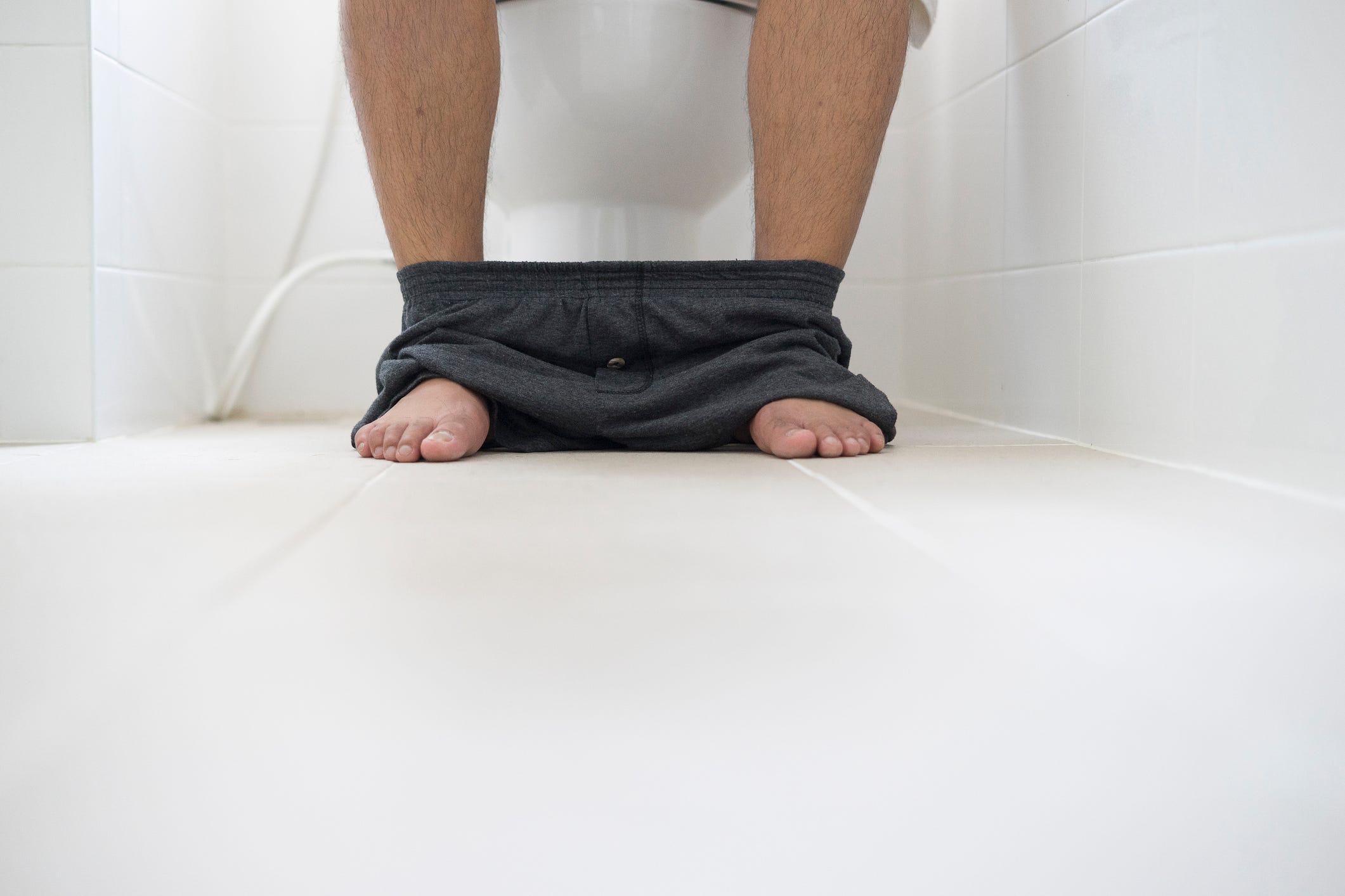 male sitting in toilet