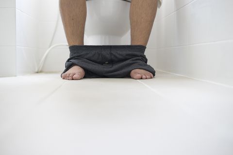 male sitting in toilet