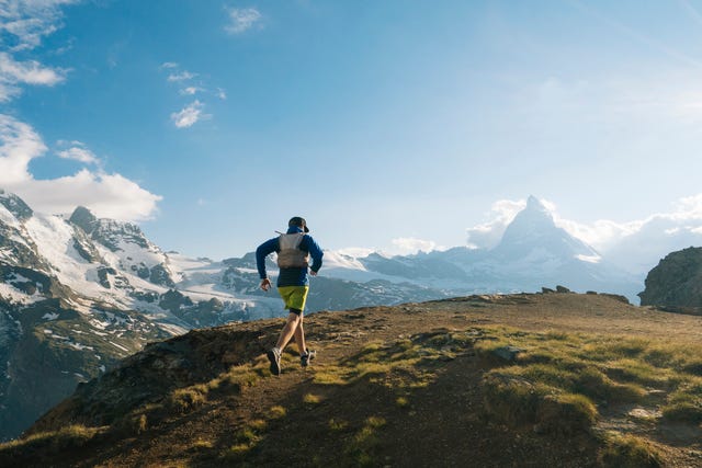 male trail runner ascends above glaciated landscape