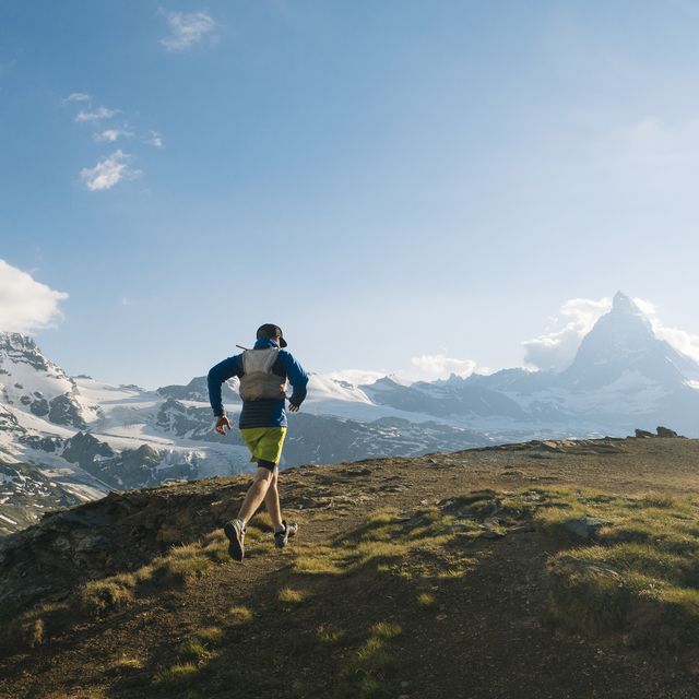 male trail runner ascends above glaciated landscape