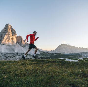 male trail runner traverses mountain ridge crest