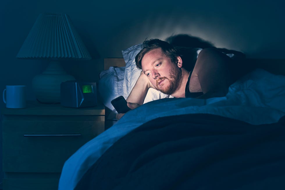 male using smartphone in bed at night